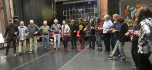 group of people holding hands in studio